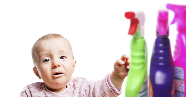 a baby with bottles of household cleaners